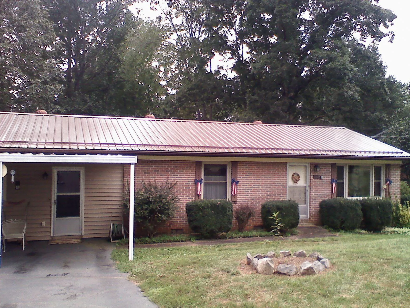 Bronze metal roof and carport on a brick ranch home — Roof Repair work by our crew in Laneview